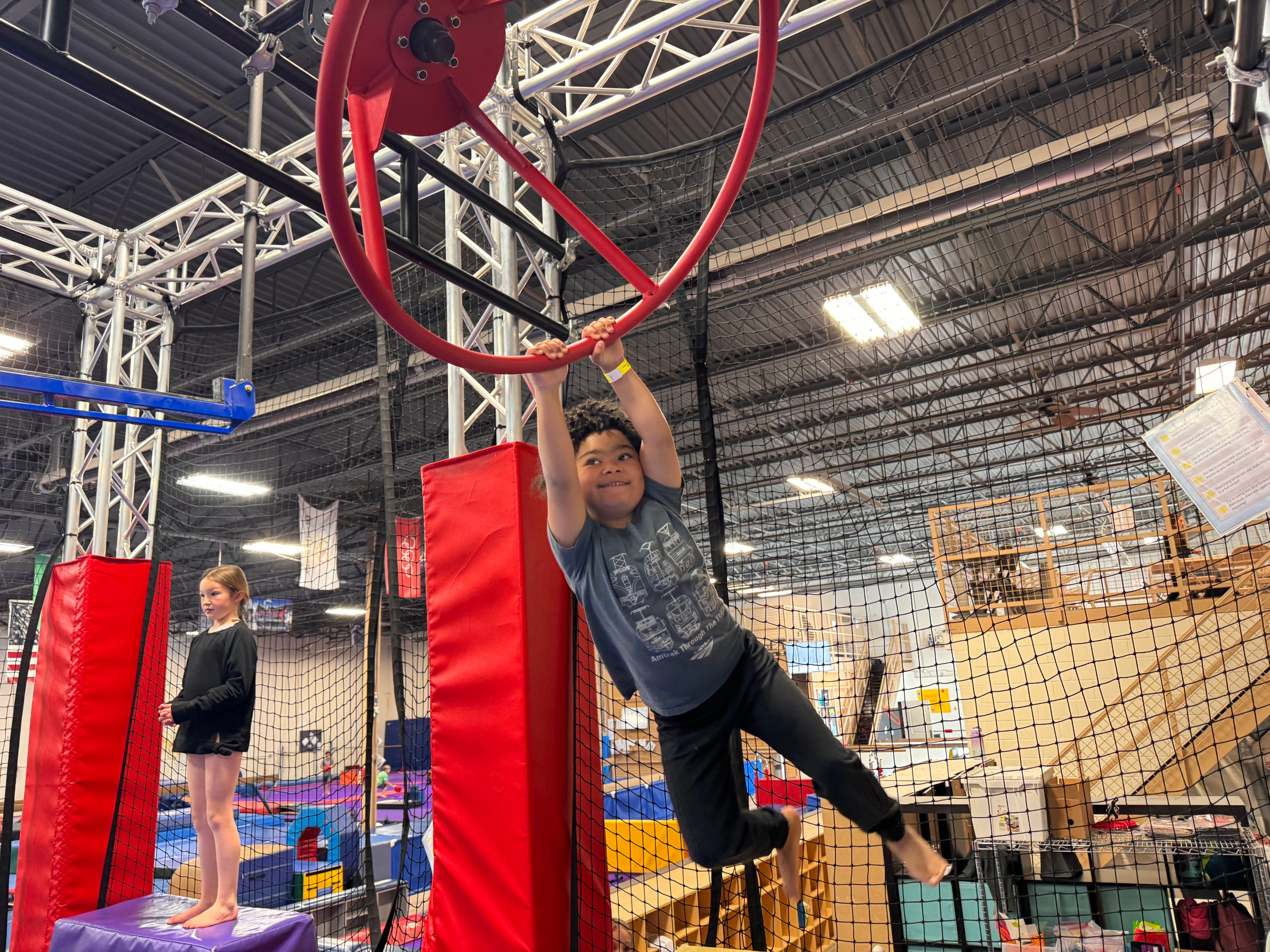 young girl hanging on gymnastics bars